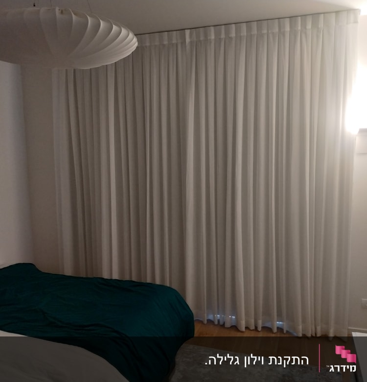 וילון לבן ארוך תלוי על קיר בחדר שינה